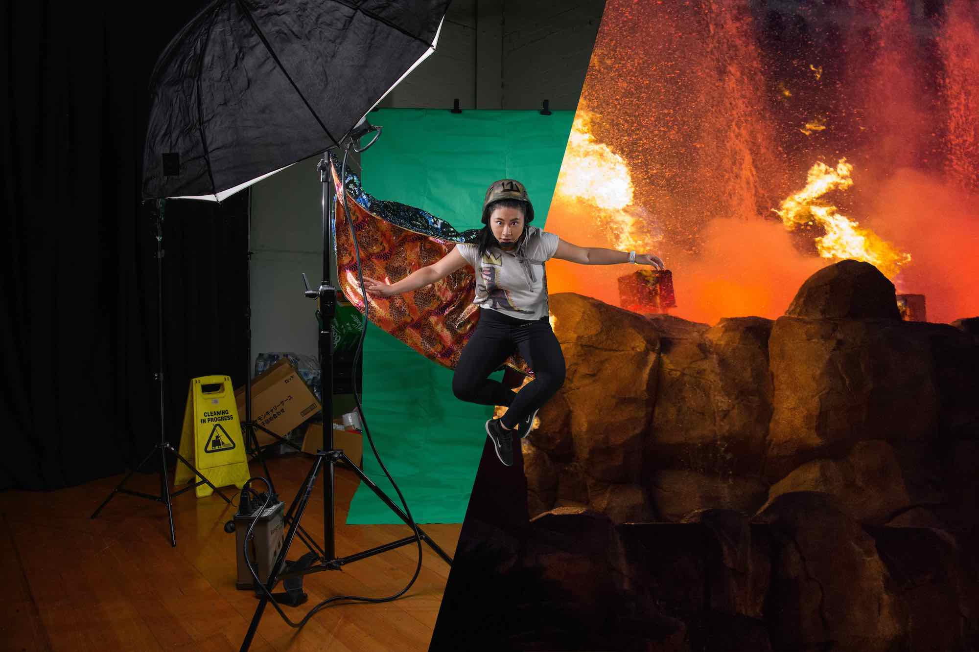 A person is centre-frame, mid-air, with a green screen on the left and explosions on the right