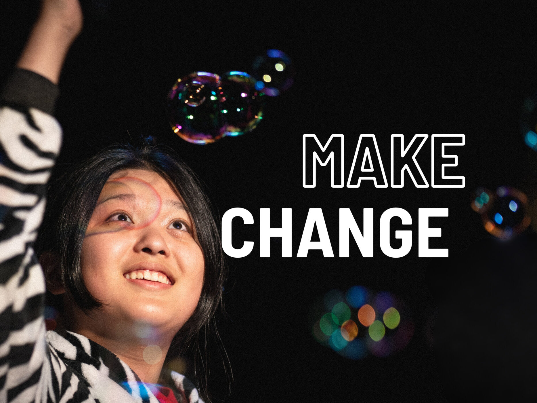 Drama workshop, child playing with soap bubbles, caption 'make change'